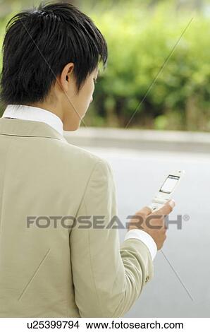 Picture - Businessman checking the email of the cell phone. Fotosearch
