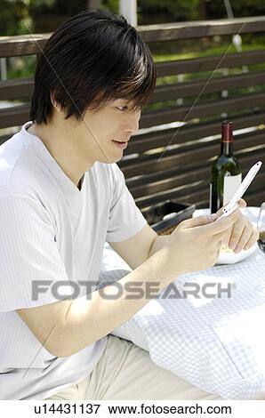 Stock Photo - Man looking at cell phone. Fotosearch