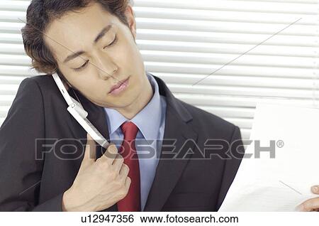 Stock Photograph - Office worker who receives on the phone. Fotosearch