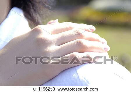 Stock Image - Couple who turns a hand to the shoulder. Fotosearch