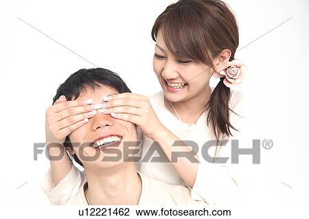 Stock Image - Woman blindfolding lover. Fotosearch