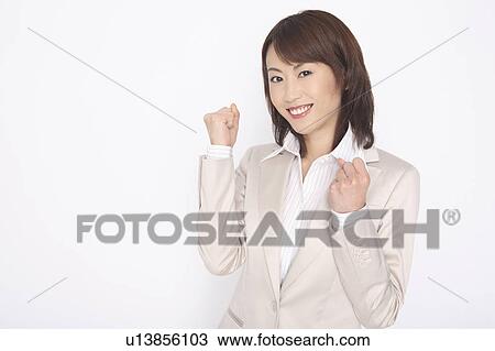 Stock Image - Business lady clenching fists in triumph. Fotosearch