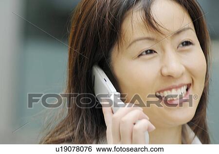 Stock Photograph - Business lady who speaks with the cell phone. Fotosearch
