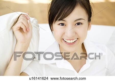 Woman holding a cushion with hand View Large Photo Image Picture - Woman holding a cushion with hand. Fotosearch