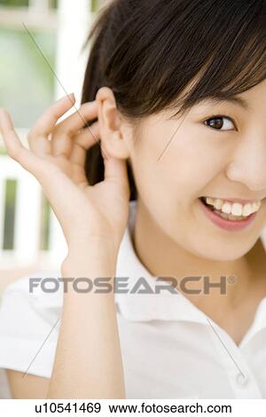Stock Photo - Woman who shows an ear. Fotosearch