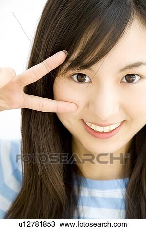 Stock Image - Wwoman who does a peace sign. Fotosearch