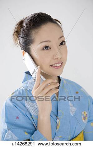 Stock Image - Yukata woman who does the phone. Fotosearch