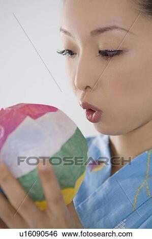 Stock Photograph - Yukata woman who swells a paper balloon. Fotosearch