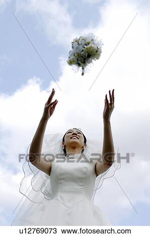 Stock Image - Bride who throws a bouquet. Fotosearch