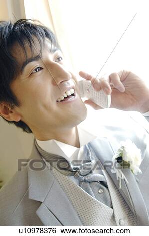 Stock Photograph - Bridegroom talking with a cell phone. Fotosearch