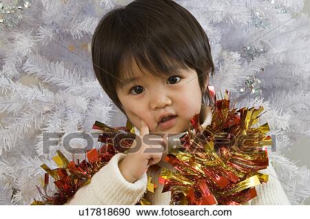 Stock Image - Boy in front of Christmas tree. Fotosearch