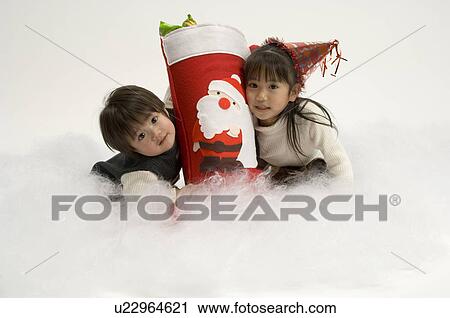 Stock Image - Brother and sister with Christmas stocking. Fotosearch
