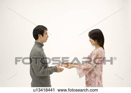Stock Image - Couple exchanging Christmas present. Fotosearch