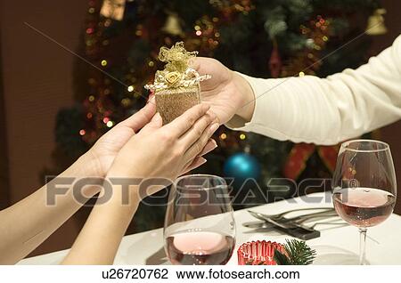 Stock Image - Couple exchanging Christmas present. Fotosearch