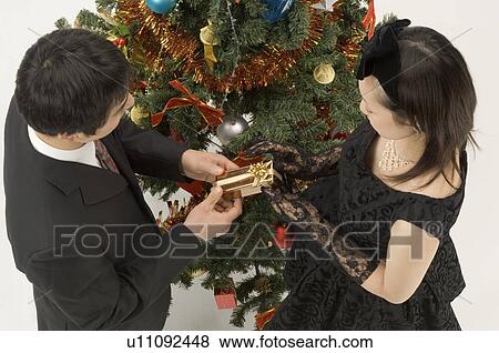 Couple exchanging Christmas present View Large Photo Image Stock Photo - Couple exchanging Christmas present. Fotosearch