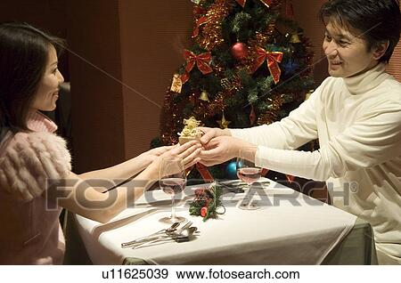 Stock Photo - Couple exchanging Christmas present. Fotosearch