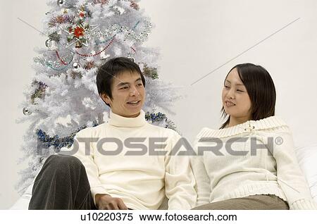 Stock Photography - Couple sitting on sofa. Fotosearch