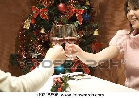Couple toasting at table in restaurant View Large Photo Image Stock Photograph - Couple toasting at table in restaurant. Fotosearch