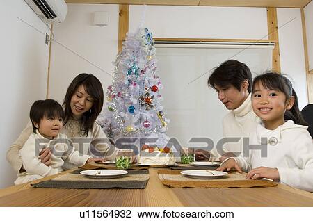 Stock Image - Family eating Christmas cake. Fotosearch