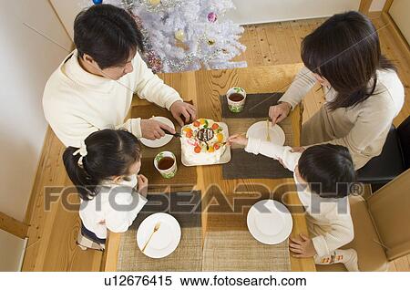 Stock Photography - Family eating Christmas cake. Fotosearch