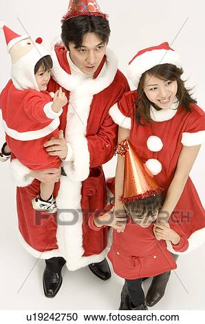 Stock Image - Family in Santa outfits. Fotosearch