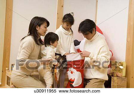 Family looking into Christmas stocking View Large Photo Image Stock Photography - Family looking into Christmas stocking. Fotosearch