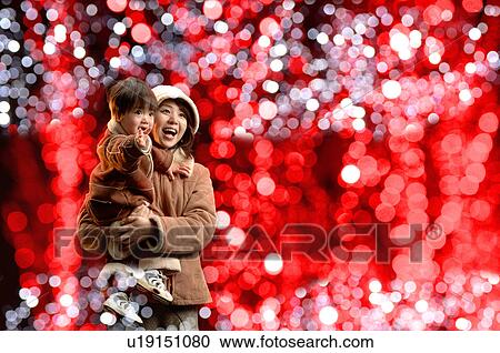 Stock Image - Mother carrying son. Fotosearch