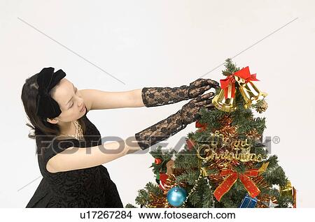 Young woman decorating Christmas tree View Large Photo Image Picture - Young woman decorating Christmas tree. Fotosearch
