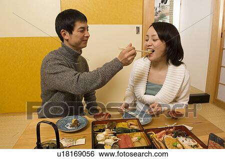 Stock Photograph - Couple having New Year's Day meal. Fotosearch