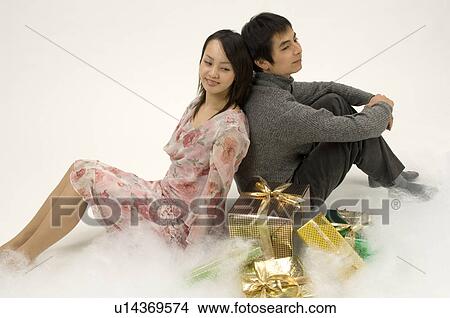 Couple sitting next to Christmas presents View Large Photo Image Picture - Couple sitting next to Christmas presents. Fotosearch