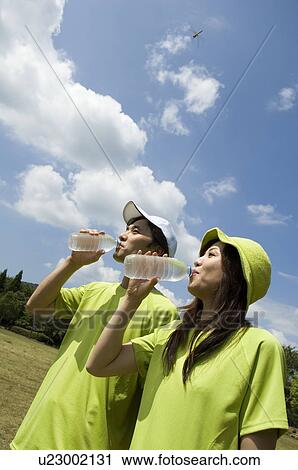 Stock Image - Husband and wife drinking water. Fotosearch