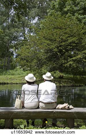 Mature couple sitting on bench View Large Photo Image Stock Image - Mature couple sitting on bench. Fotosearch