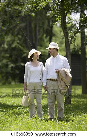 Mature couple walking in park View Large Photo Image Stock Image - Mature couple walking in park. Fotosearch