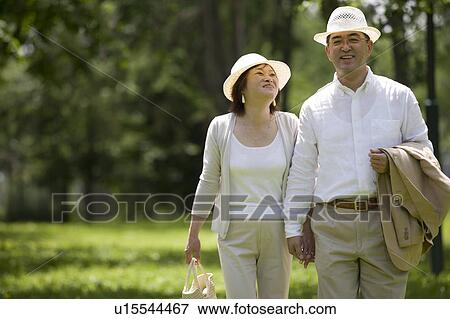 Stock Photo - Mature couple walking in park. Fotosearch