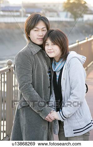 Stock Photo - Portrait of young couple embracing. Fotosearch
