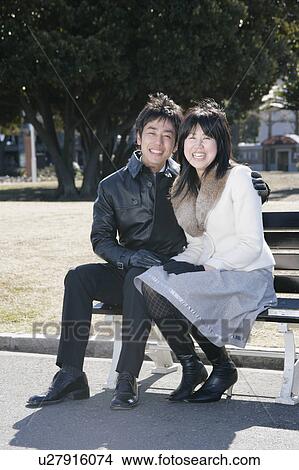 Picture - Portrait of young couple sitting. Fotosearch