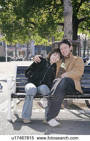 Stock Photography - Portrait of young couple sitting. Fotosearch