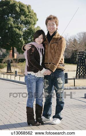 Stock Image - Portrait of young couple standing. Fotosearch