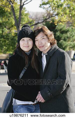 Stock Image - Portrait of young couple standing. Fotosearch