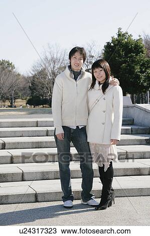 Stock Image - Portrait of young couple standing. Fotosearch