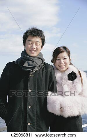 Stock Image - Portrait of young couple standing. Fotosearch