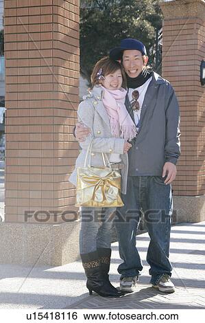 Stock Photograph - Portrait of young couple standing. Fotosearch