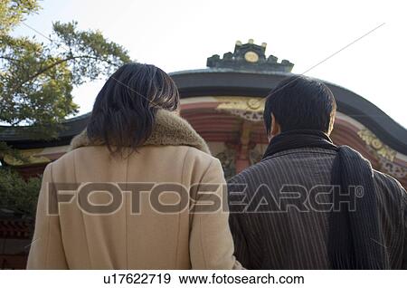 Stock Photo - Rear view of couple at shrine. Fotosearch
