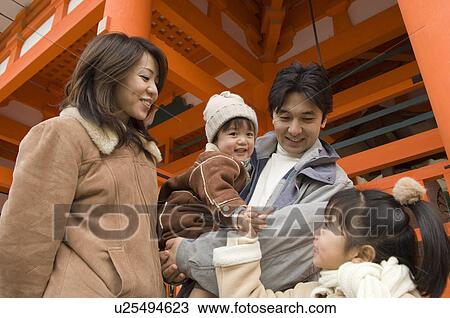 Stock Image - Family at shrine. Fotosearch