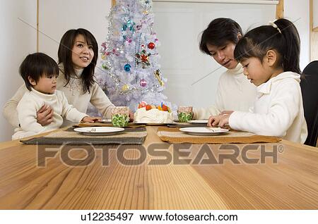 Stock Photo - Family eating Christmas cake. Fotosearch