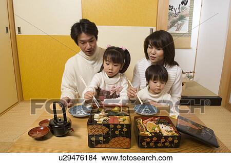 Picture - Family eating New Year's Day meal. Fotosearch