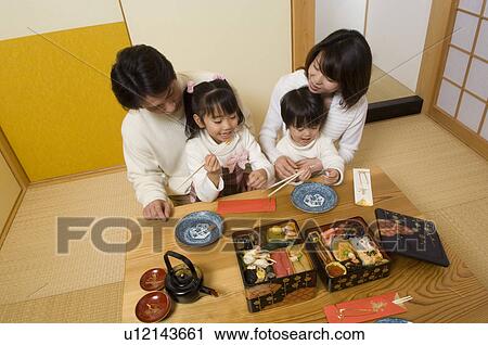 Family eating New Year's Day meal View Large Photo Image Stock Image - Family eating New Year's Day meal. Fotosearch