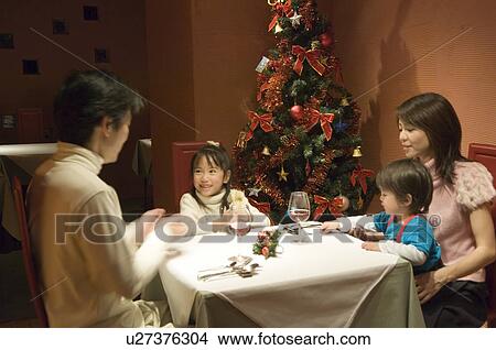 Family sitting at table View Large Photo Image Picture - Family sitting at table. Fotosearch