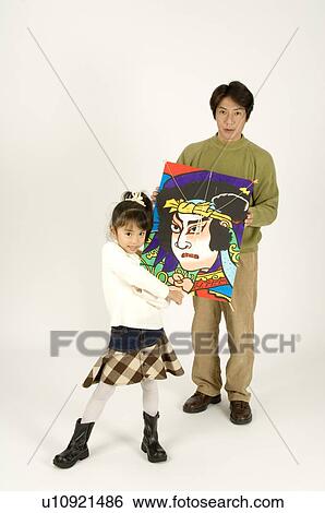 Stock Photograph - Father and daughter holding kite. Fotosearch