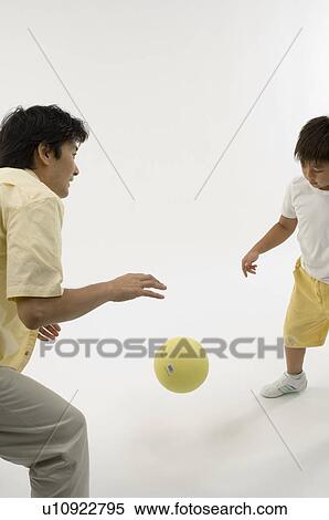 Stock Photography - Father and son playing with ball. Fotosearch